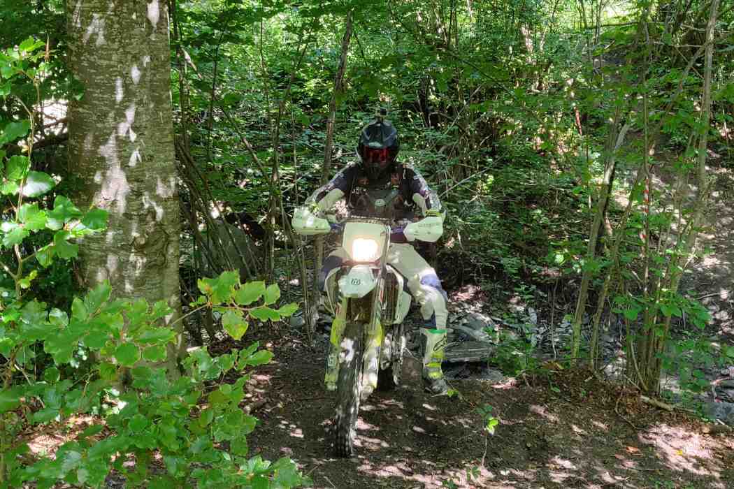 saliendo del bosque en los alpes, con la moto de enduro en el tour ENDURO ALPES by o2riders