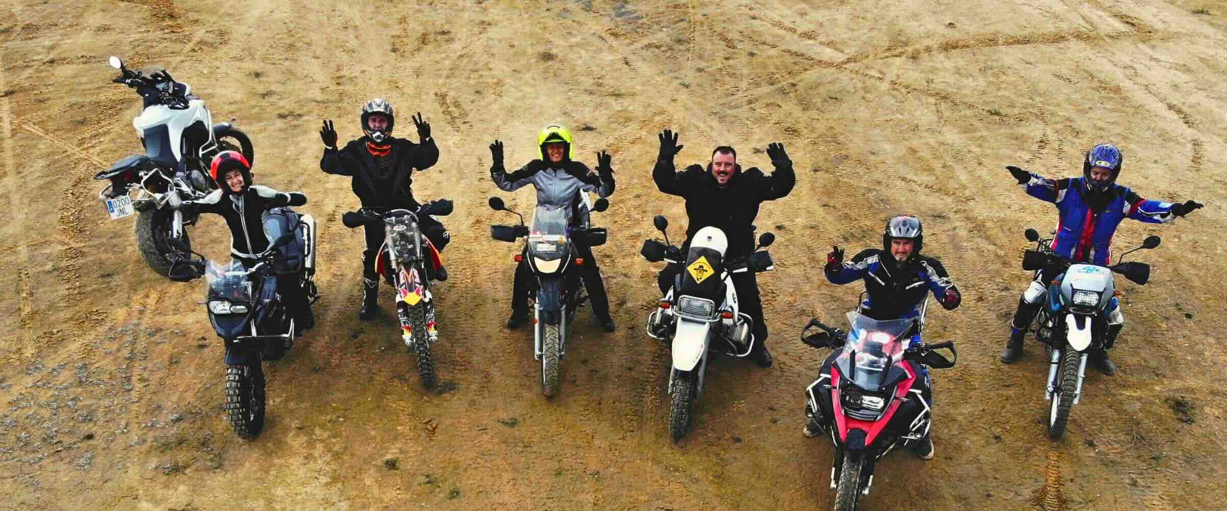 Grupo de motoristas con sus motos durante una actividad de formación trail